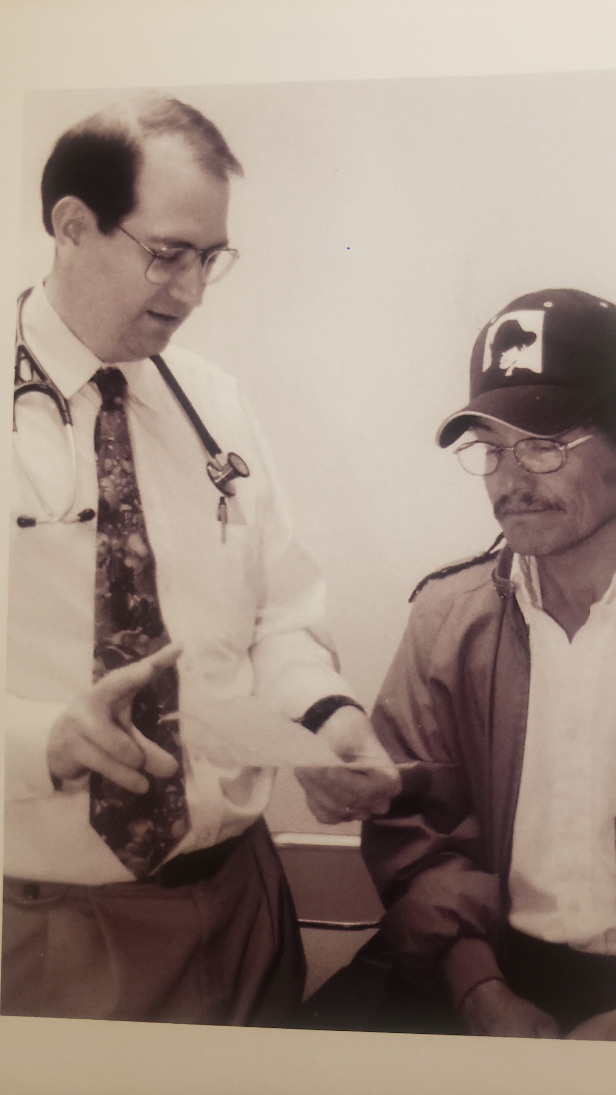 Dr. Moore stands next to a patient holding a piece of paper